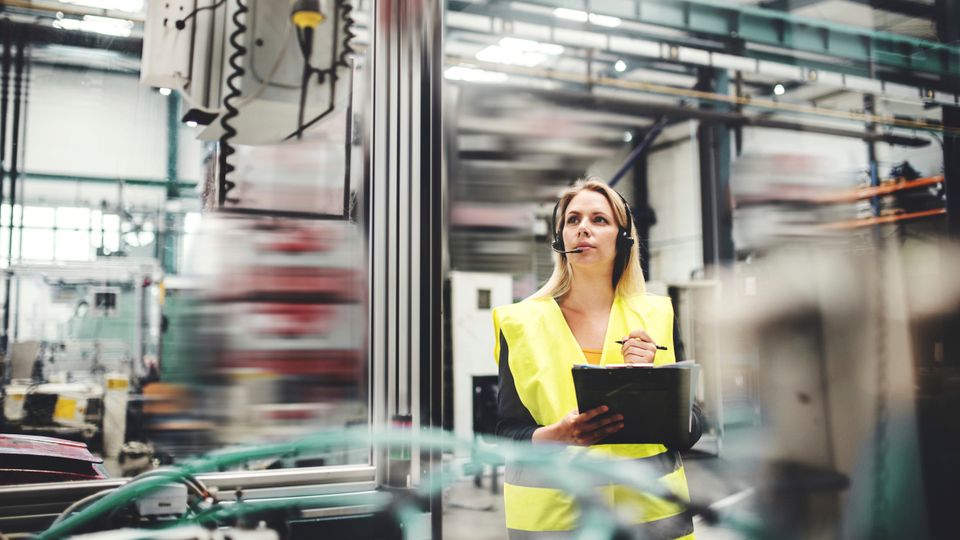 industrial woman engineer with headset in a factory, working. copy space.